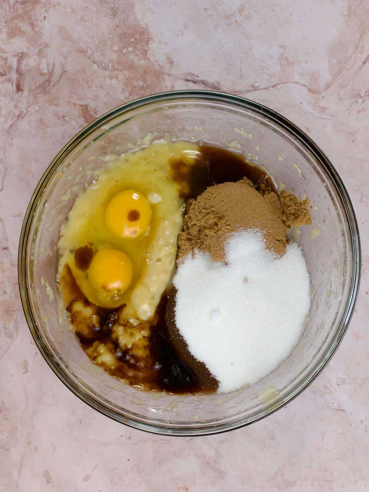 mashed banana, eggs, vanilla, sugar, butter in a glass bowl