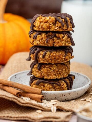 A stack of no bake pumpkin cookies on a plate.