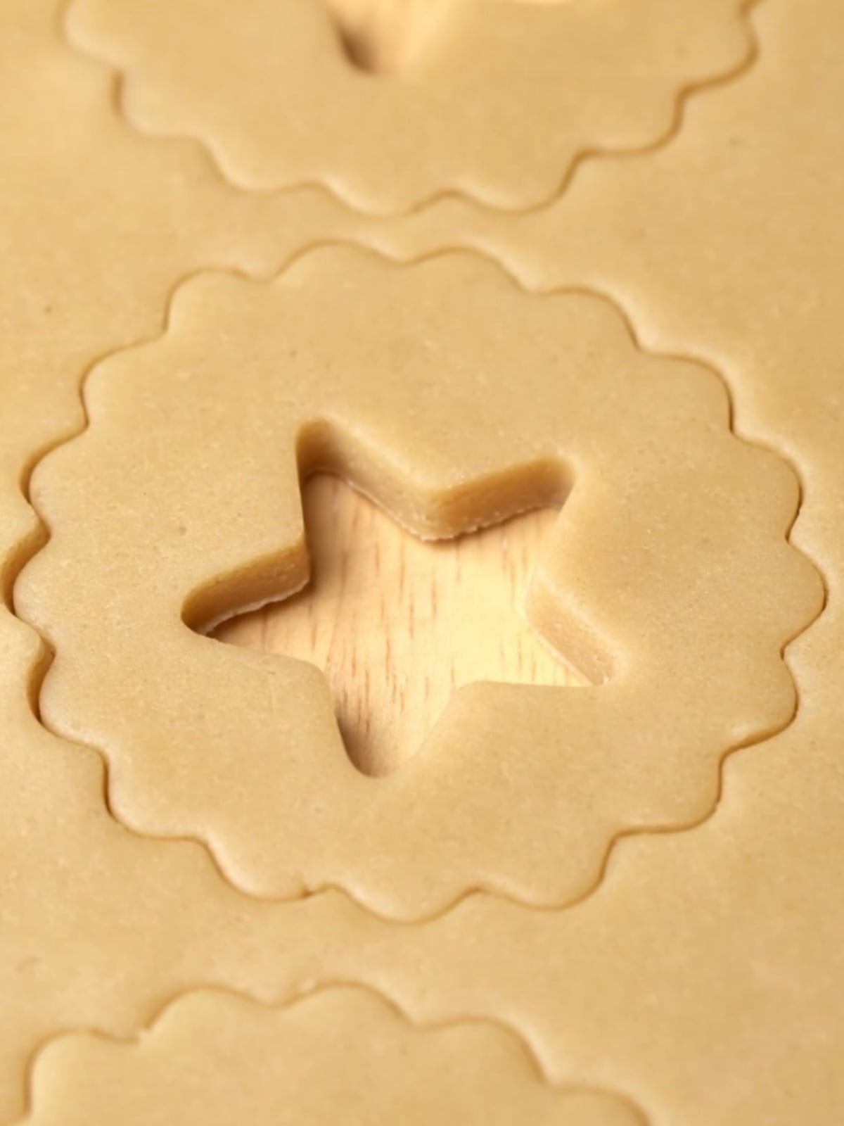 Espresso cookie dough with a scalloped edge circle and star cutout.