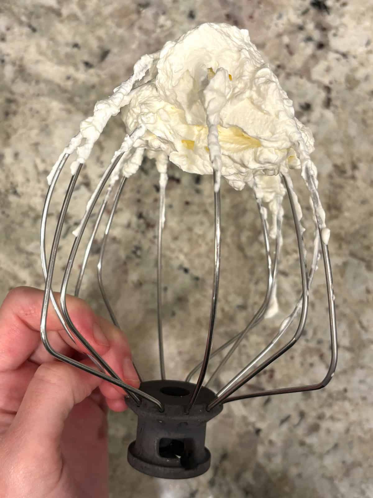 Heavy cream whipped to stiff peaks on a whisk attachment.