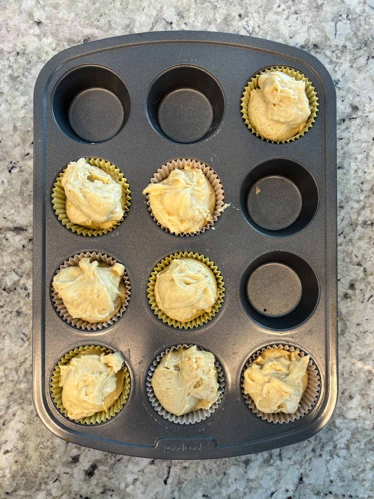 A muffin pan filled with muffin liners with batter in the muffin liners.