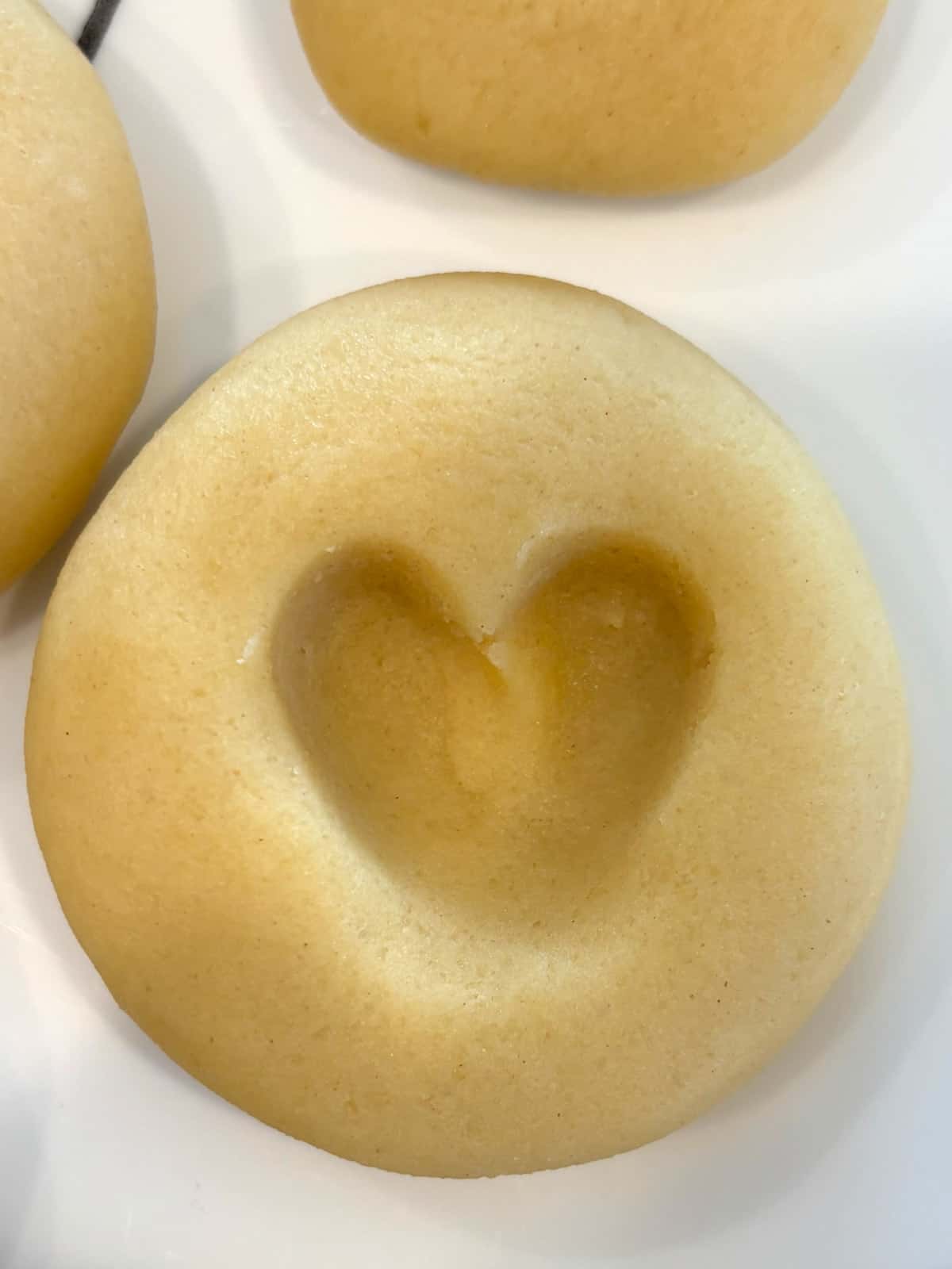 Raw shortbread cookie dough with a heart indentation, ready to be frozen.