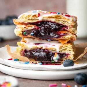 Pop tarts stacked on a plate with icing and sprinkles.