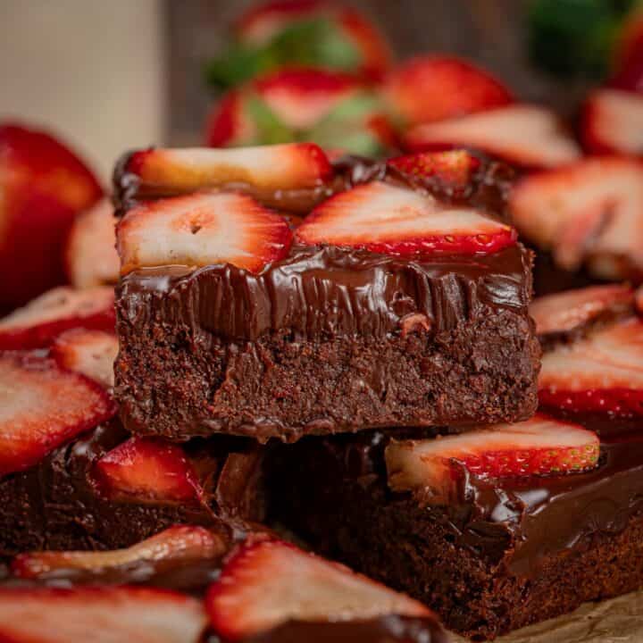 Strawberry chocolate brownies stacked showing the textures of the brownies.