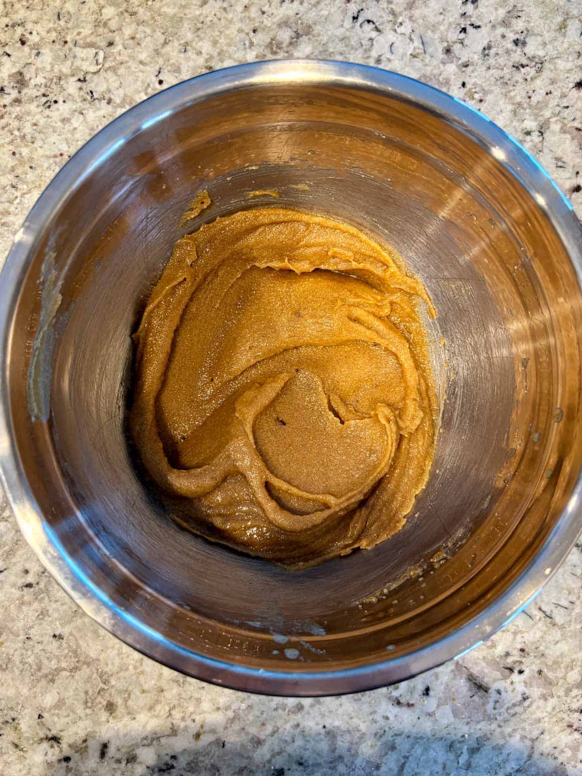 Melted butter, dark brown sugar, and sugar in a bowl mixed together.