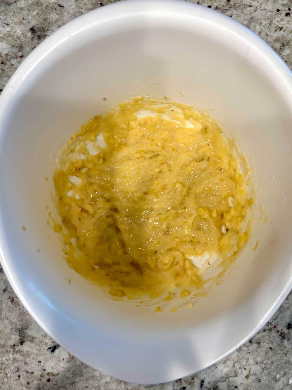 Mashed banana in a bowl before adding all of the other ingredients.