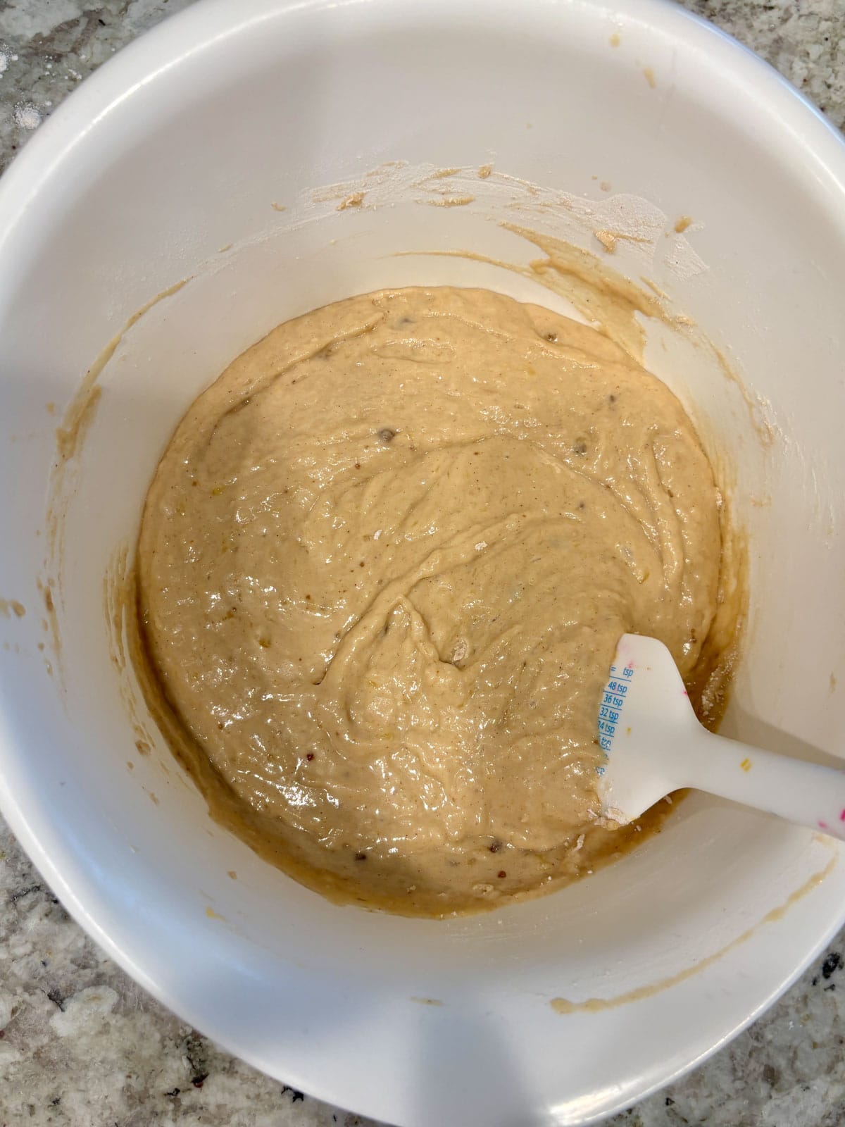 Banana muffin batter after the flour was added in the bowl.