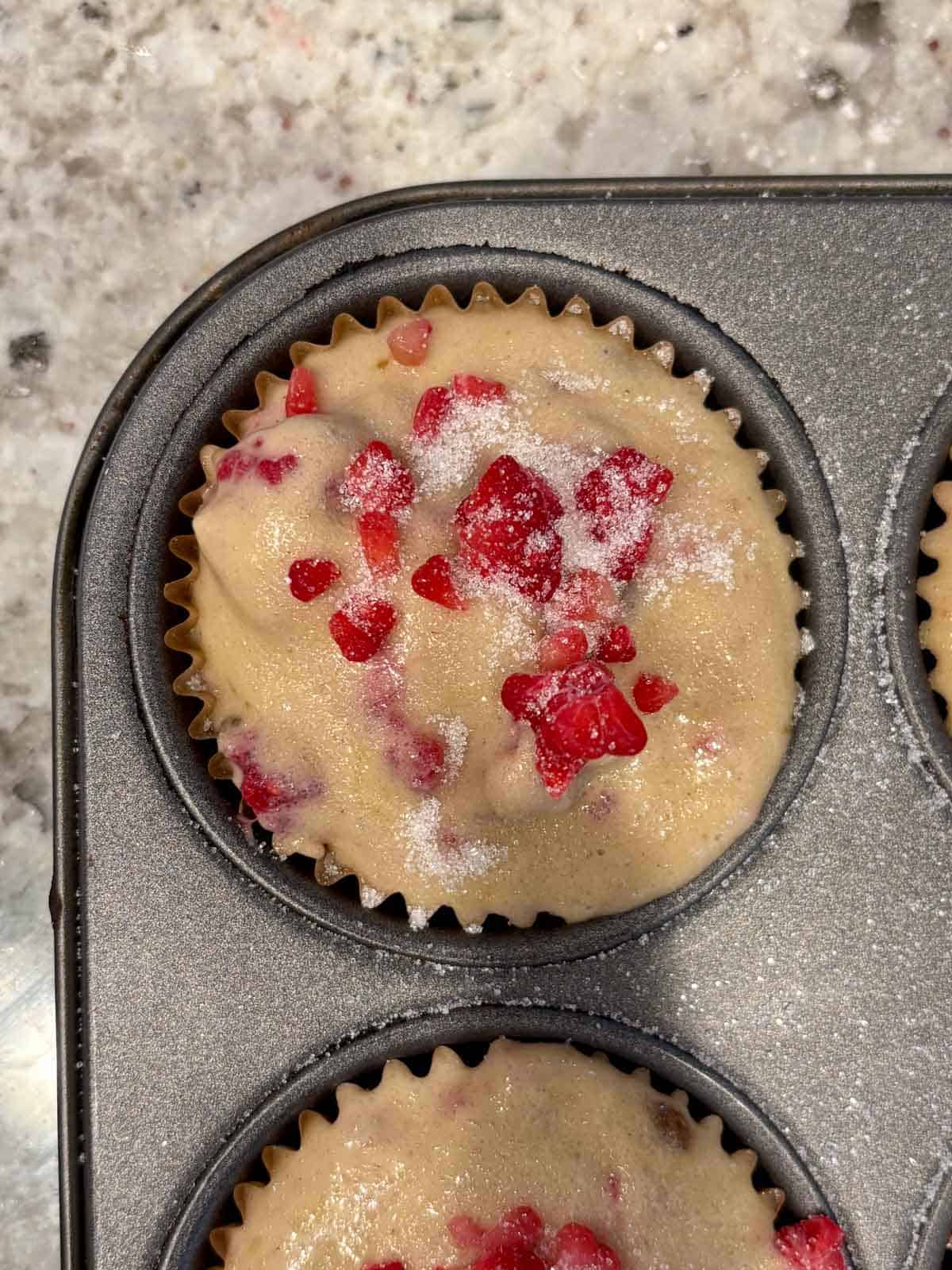 Muffin batter topped with granulated sugar before going in the oven.