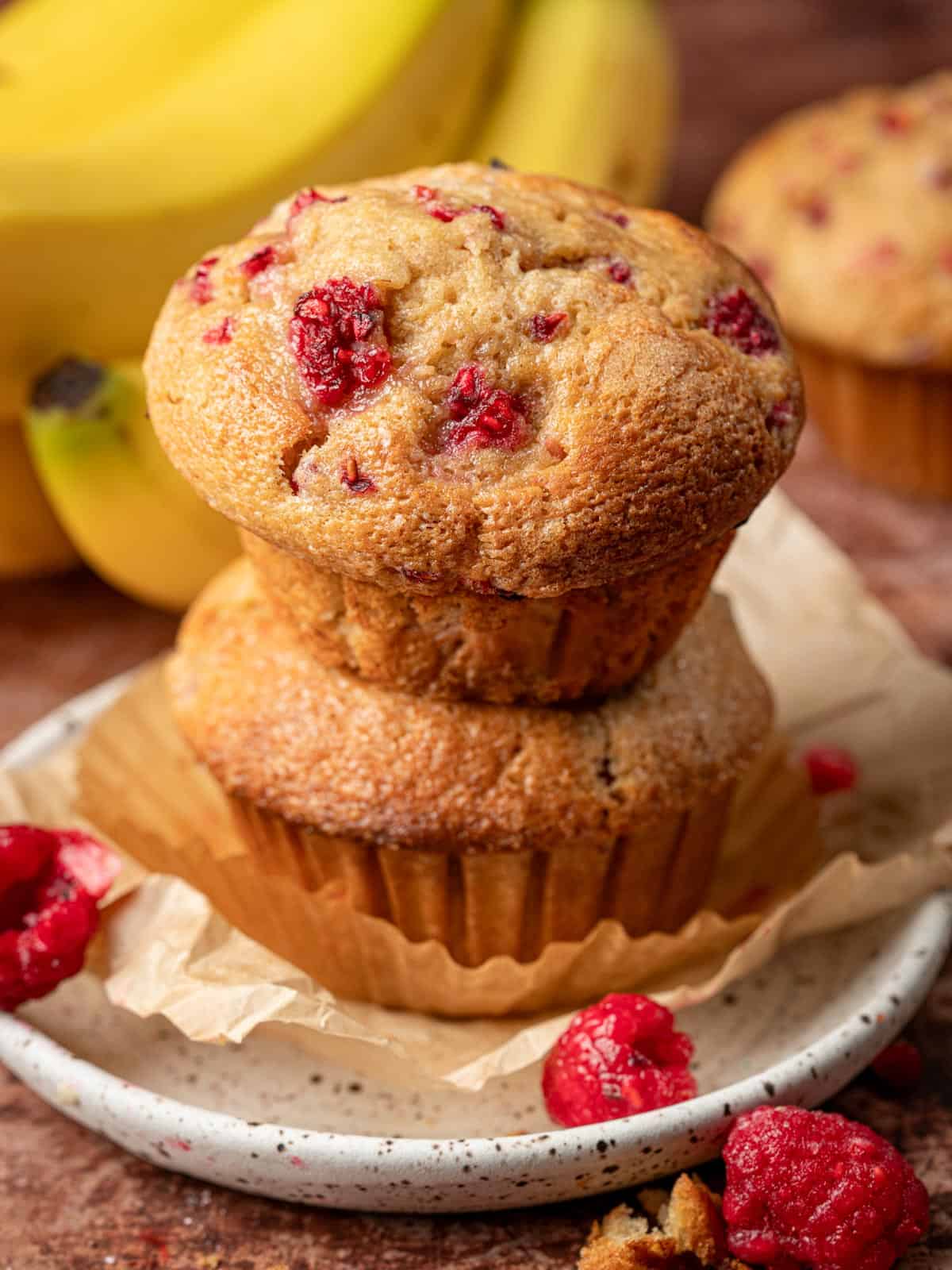 Two berry muffin stacked on top of each other showing the tops.