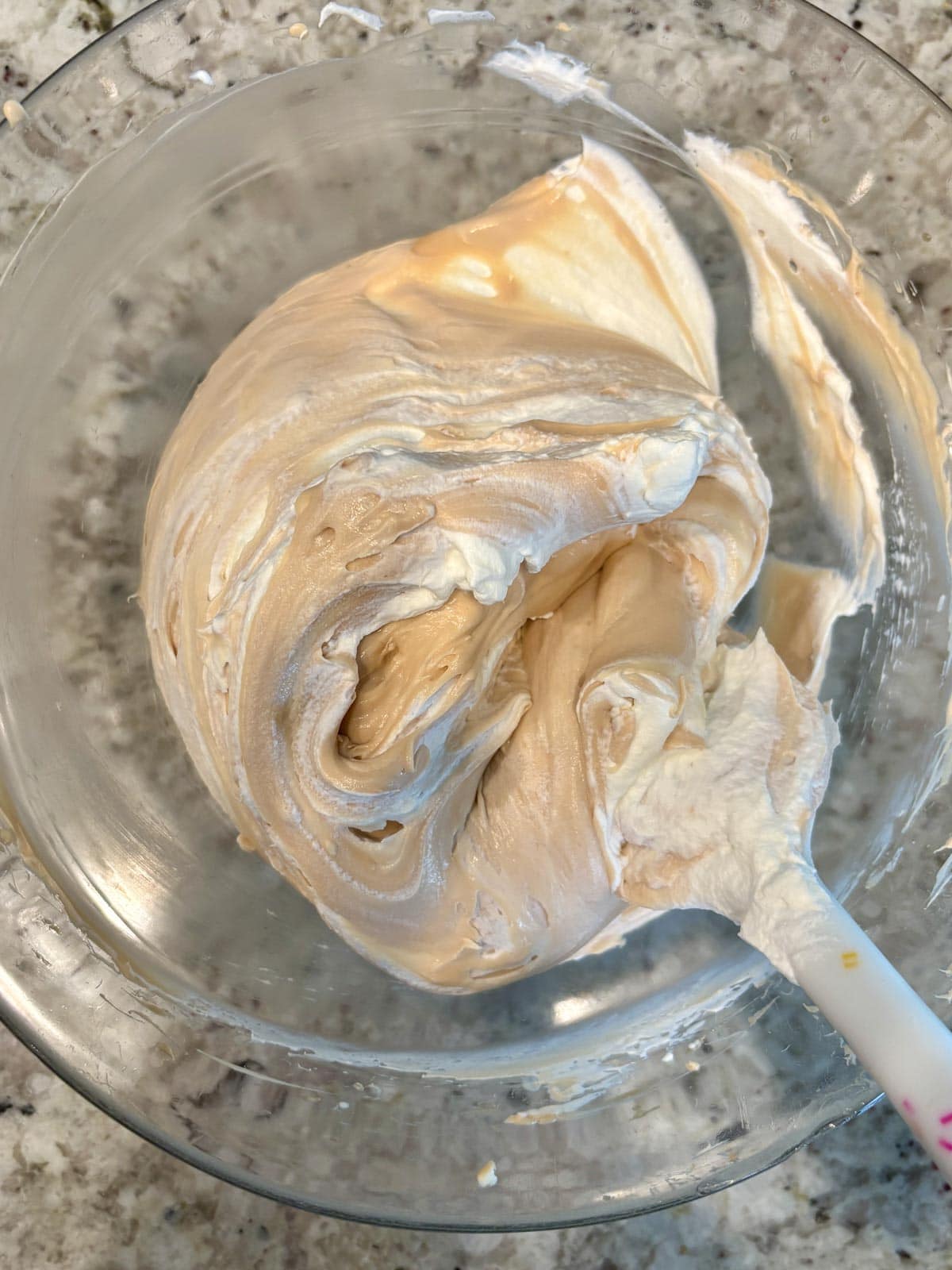 Salted caramel and cream cheese being folded with heavy cream.