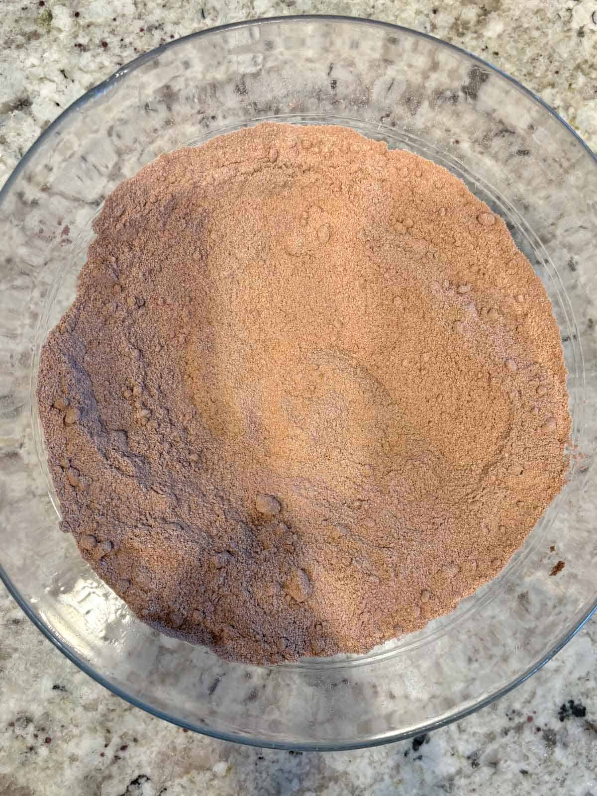 The dry ingredients in a bowl on the counter mixed together.