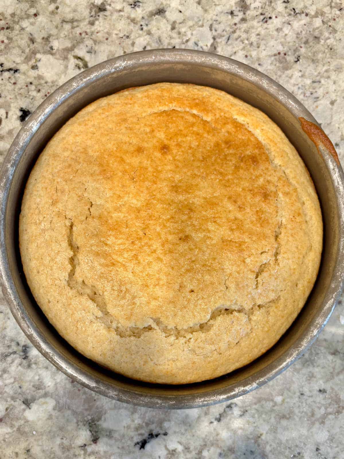Baked cake in a cake pan right after it has come out of the oven.