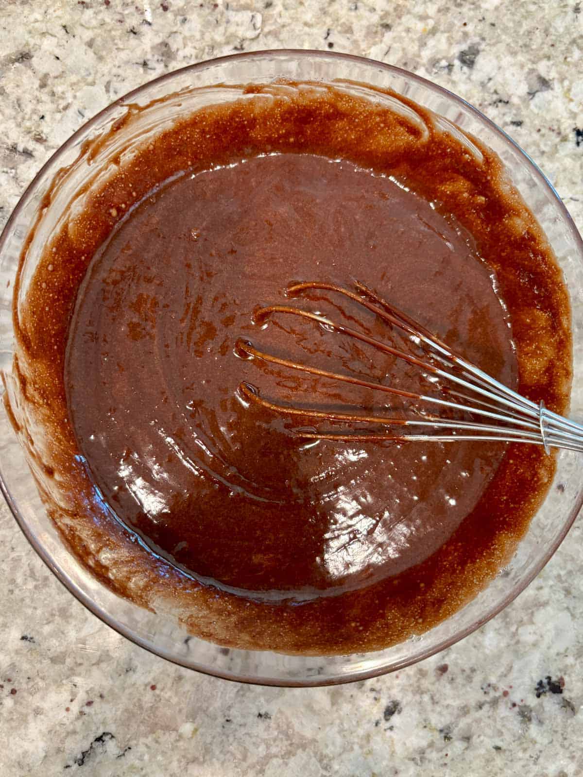 The melted chocolate mixture with the egg mixture in a bowl.