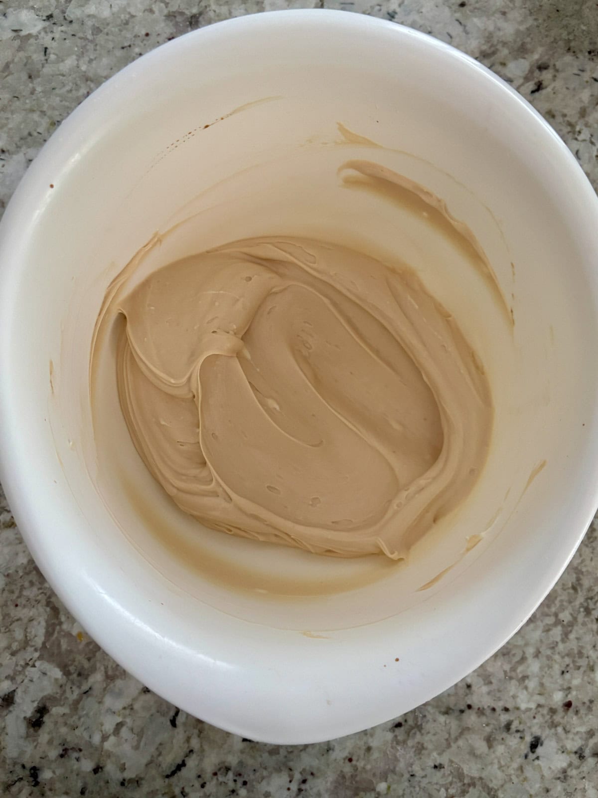 Cream cheese and salted caramel sauce mixed until smooth in a bowl.