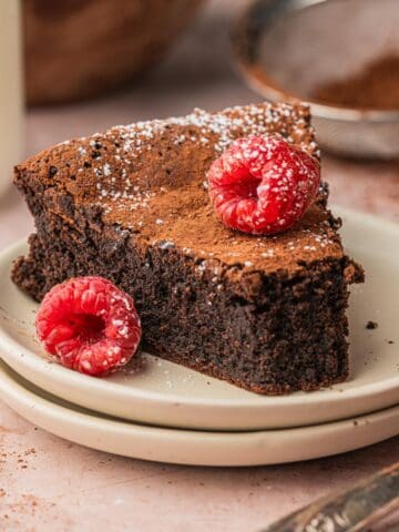 A piece of the chocolate torte on a plate with raspberries.