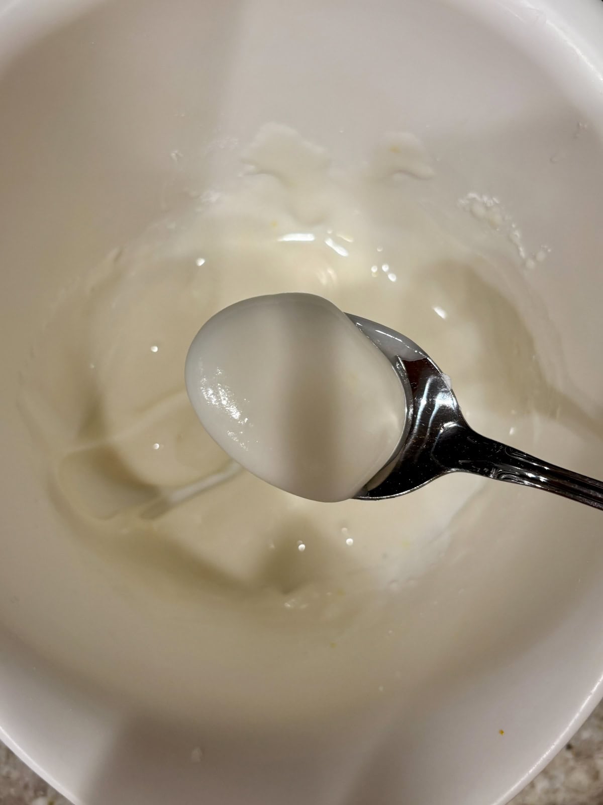 Lemon icing in a bowl showing how thick it should be.