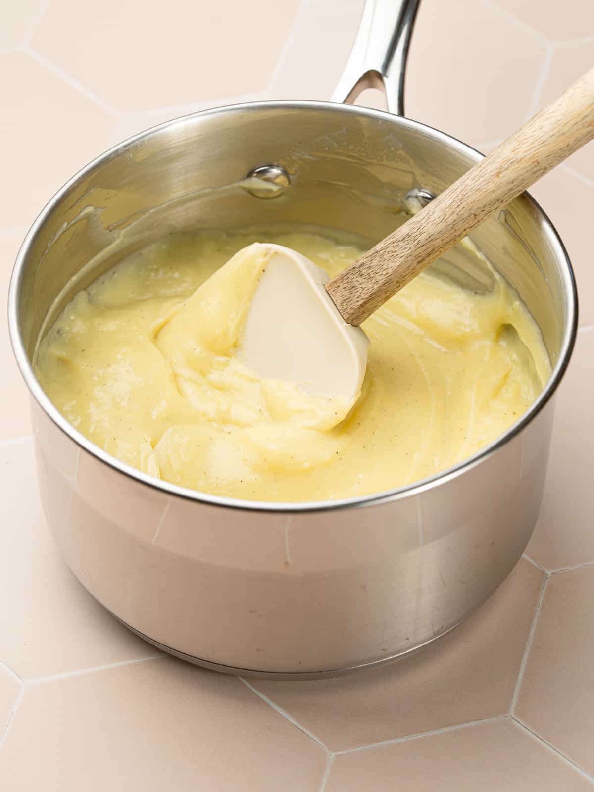 The finished pastry cream in a medium saucepan on the counter.