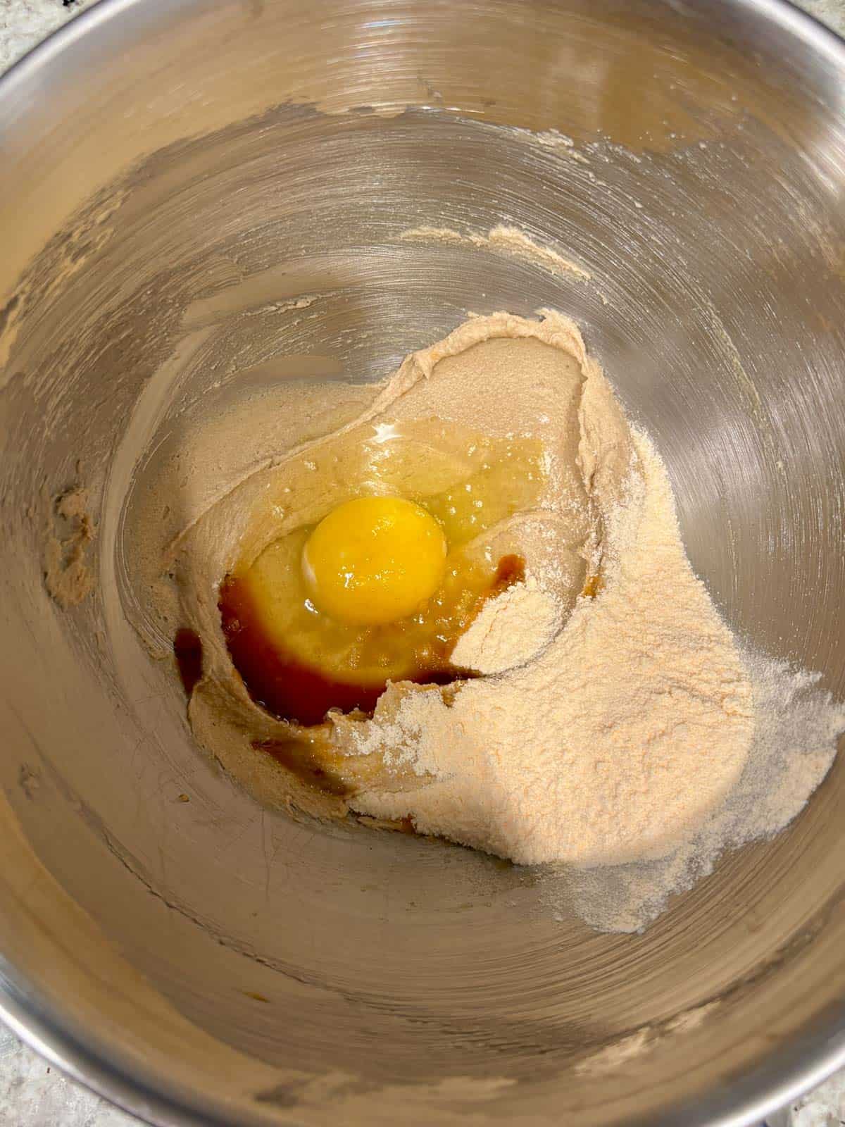 Egg, vanilla extract, and pudding powder being added to the butter mixture.