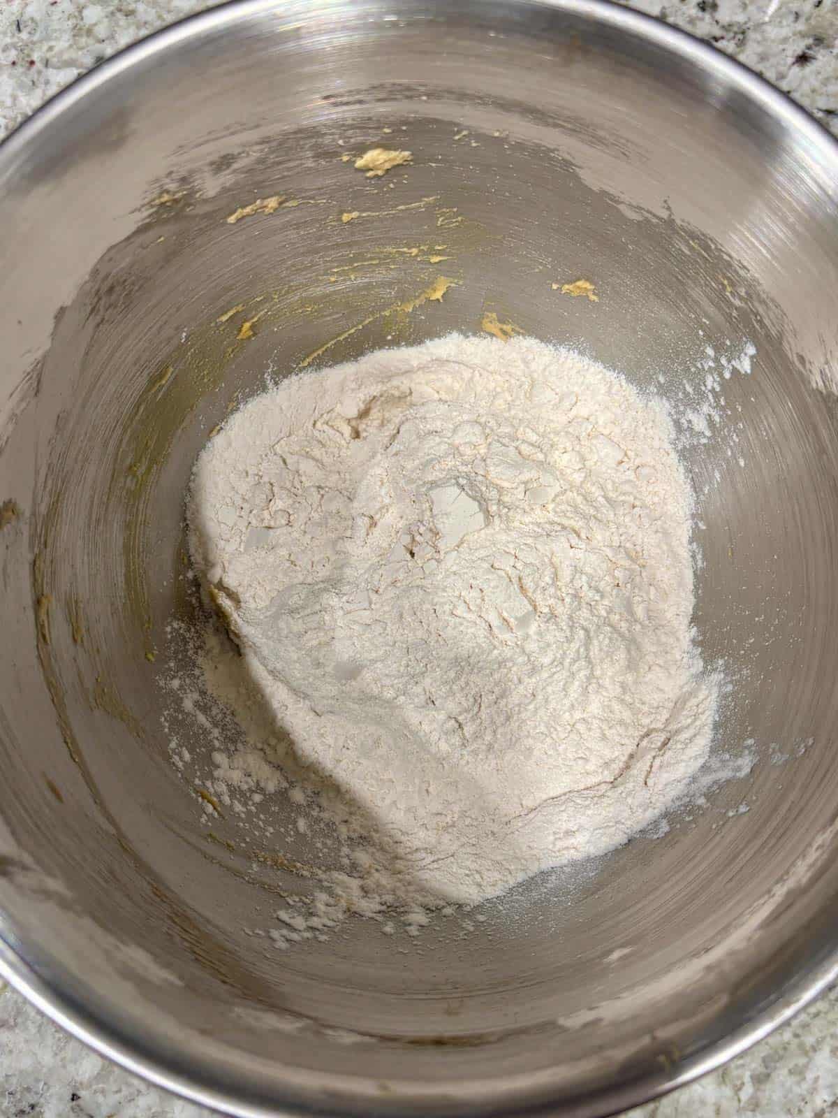 Flour, baking soda, and salt being added to the mixing bowl.