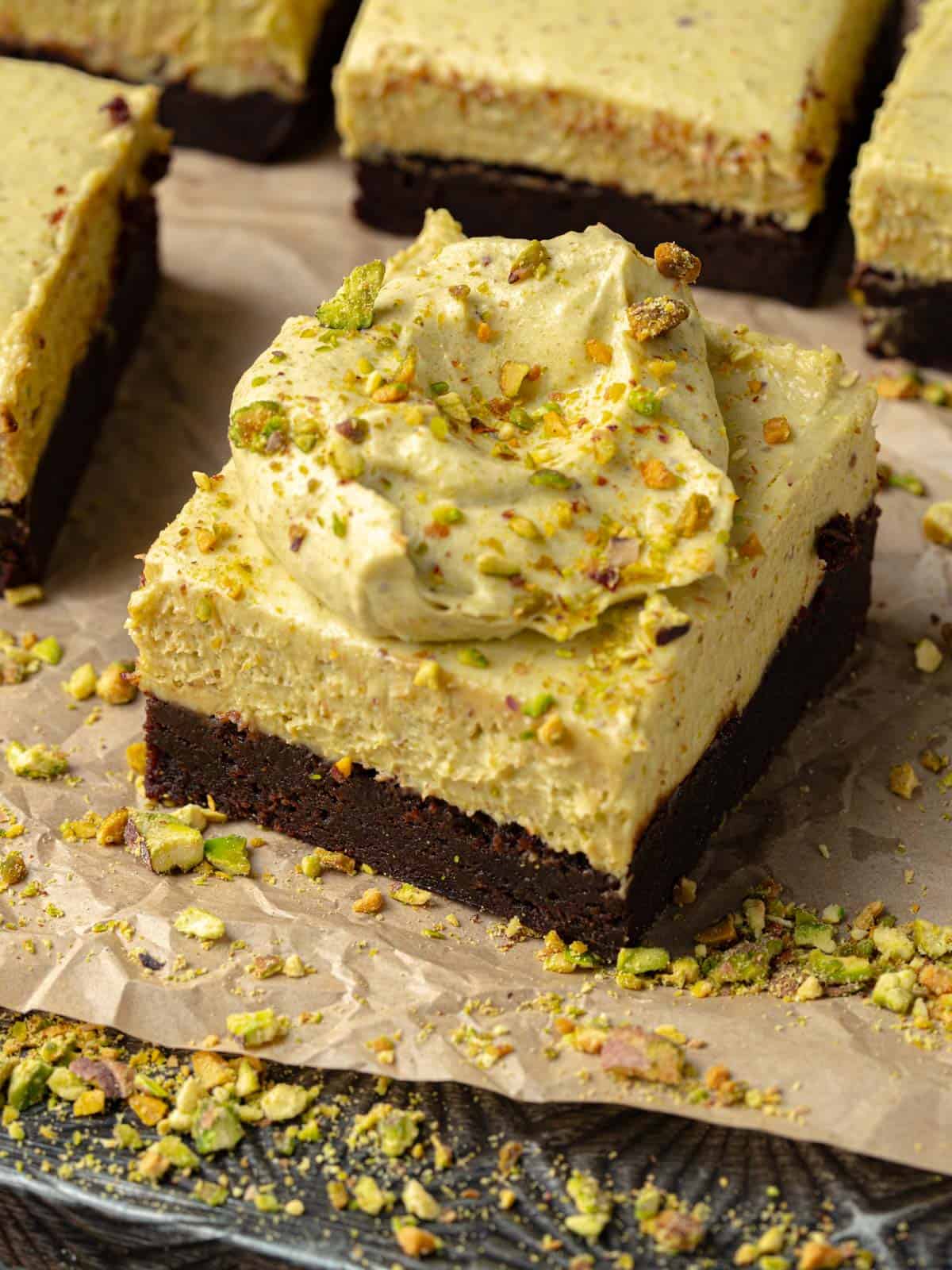 Pistachio chocolate brownies with chopped pistachios on top on a cookie sheet.