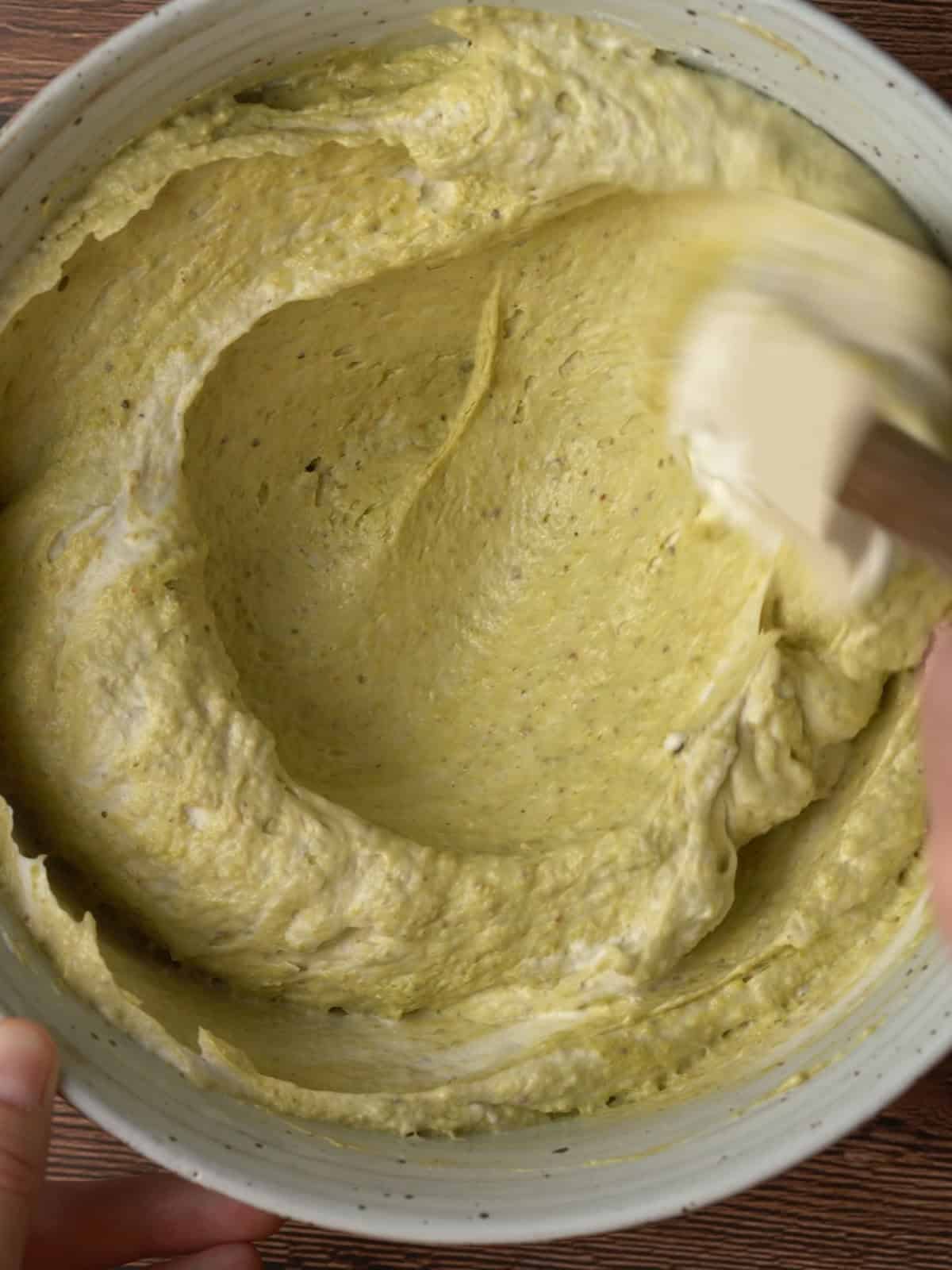 Whipped cream being folded into the pistachio cream cheese mixture.