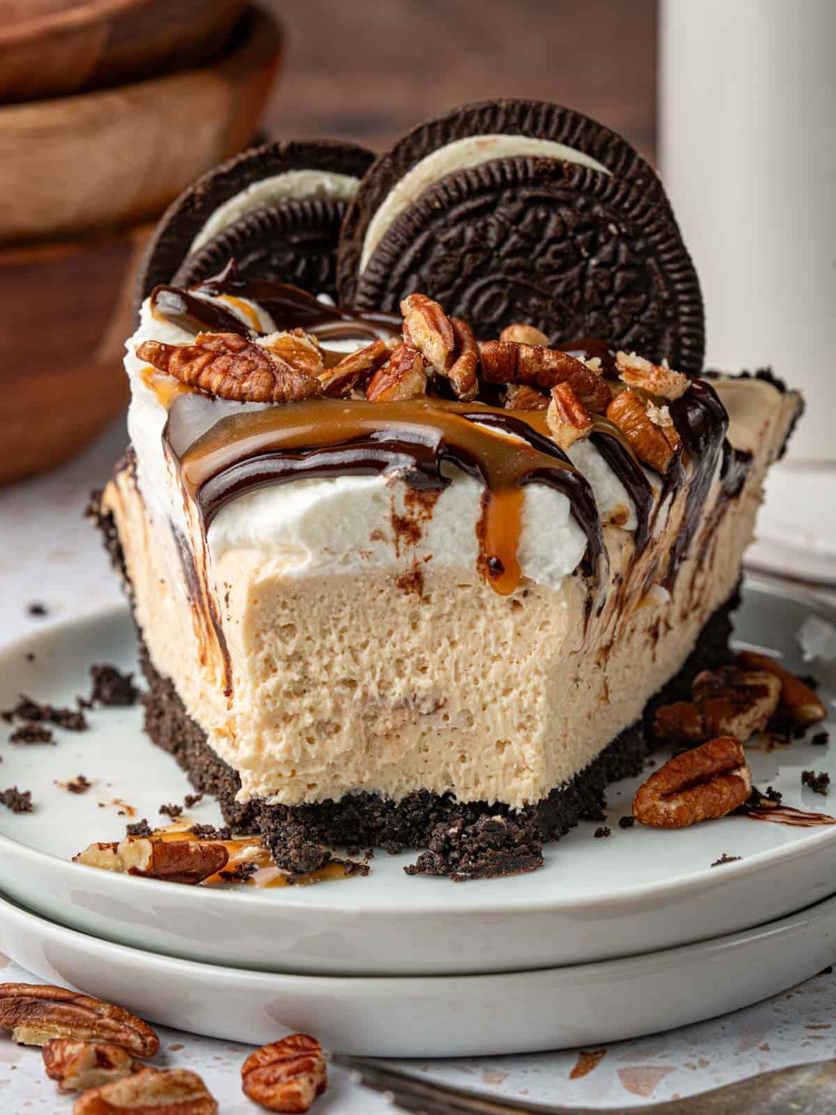 A slice of chocolate caramel pecan pie with a piece missing.