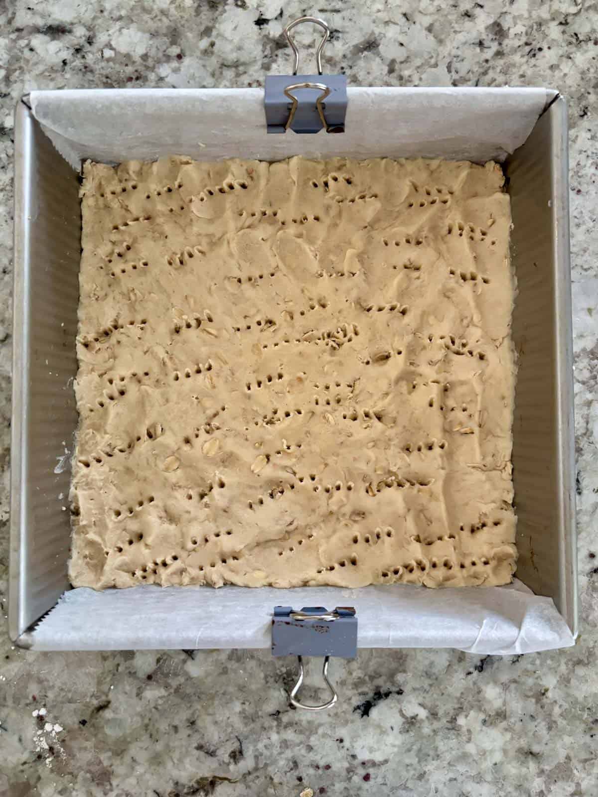 Shortbread dough pushed evenly into the bottom of the baking pan.