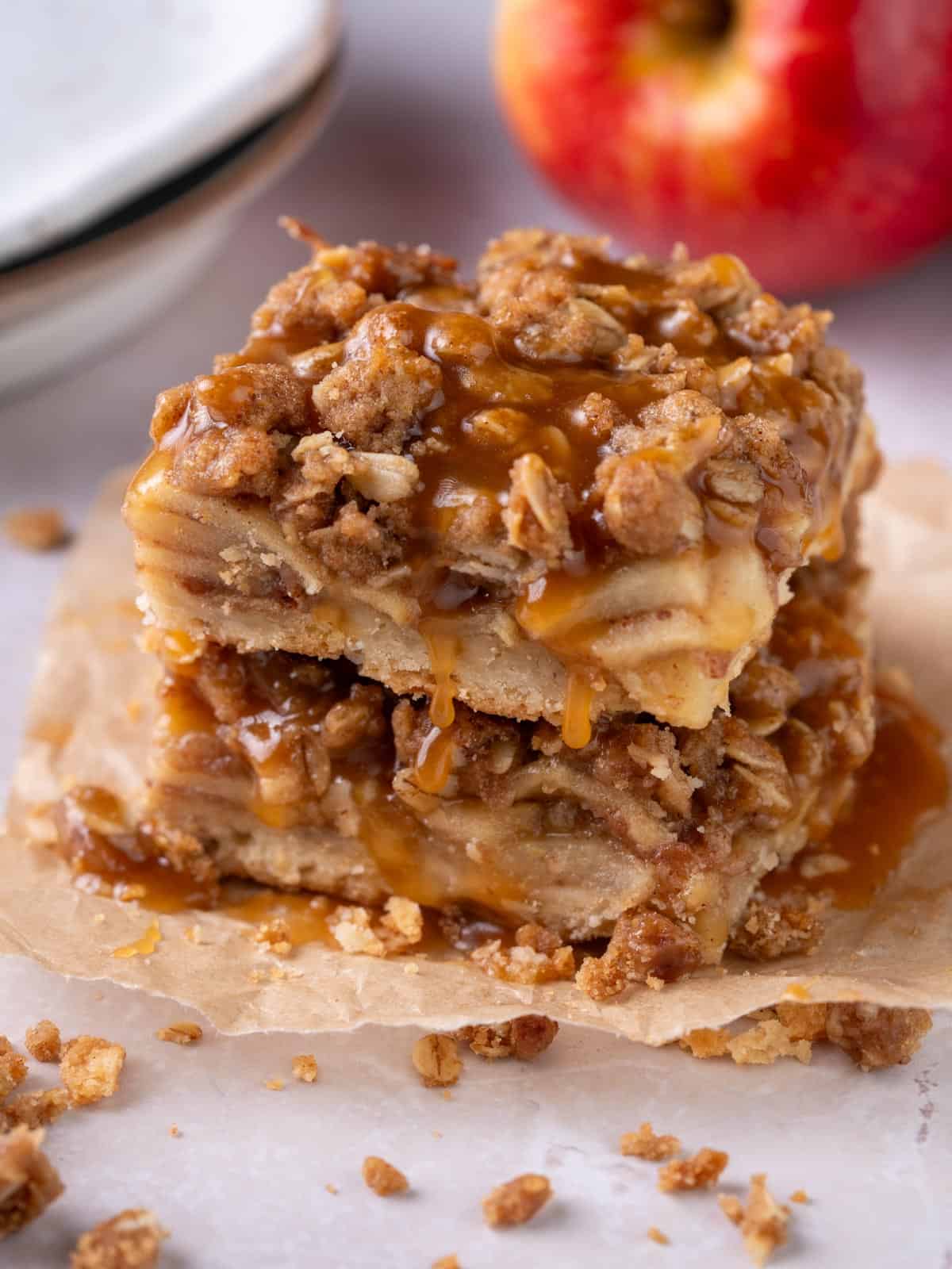 A stack of apple bars with salted caramel on top and oats around.