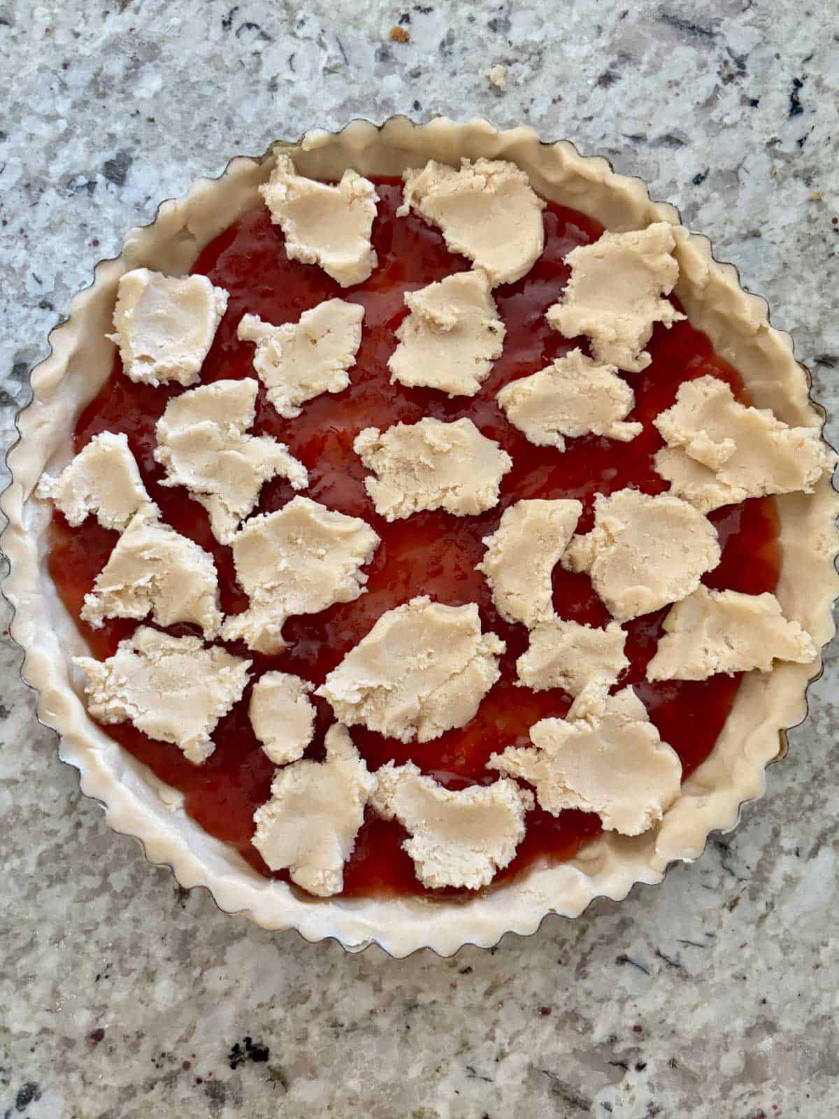 The tart dough filled with strawberry jam and topped with tart dough pieces.
