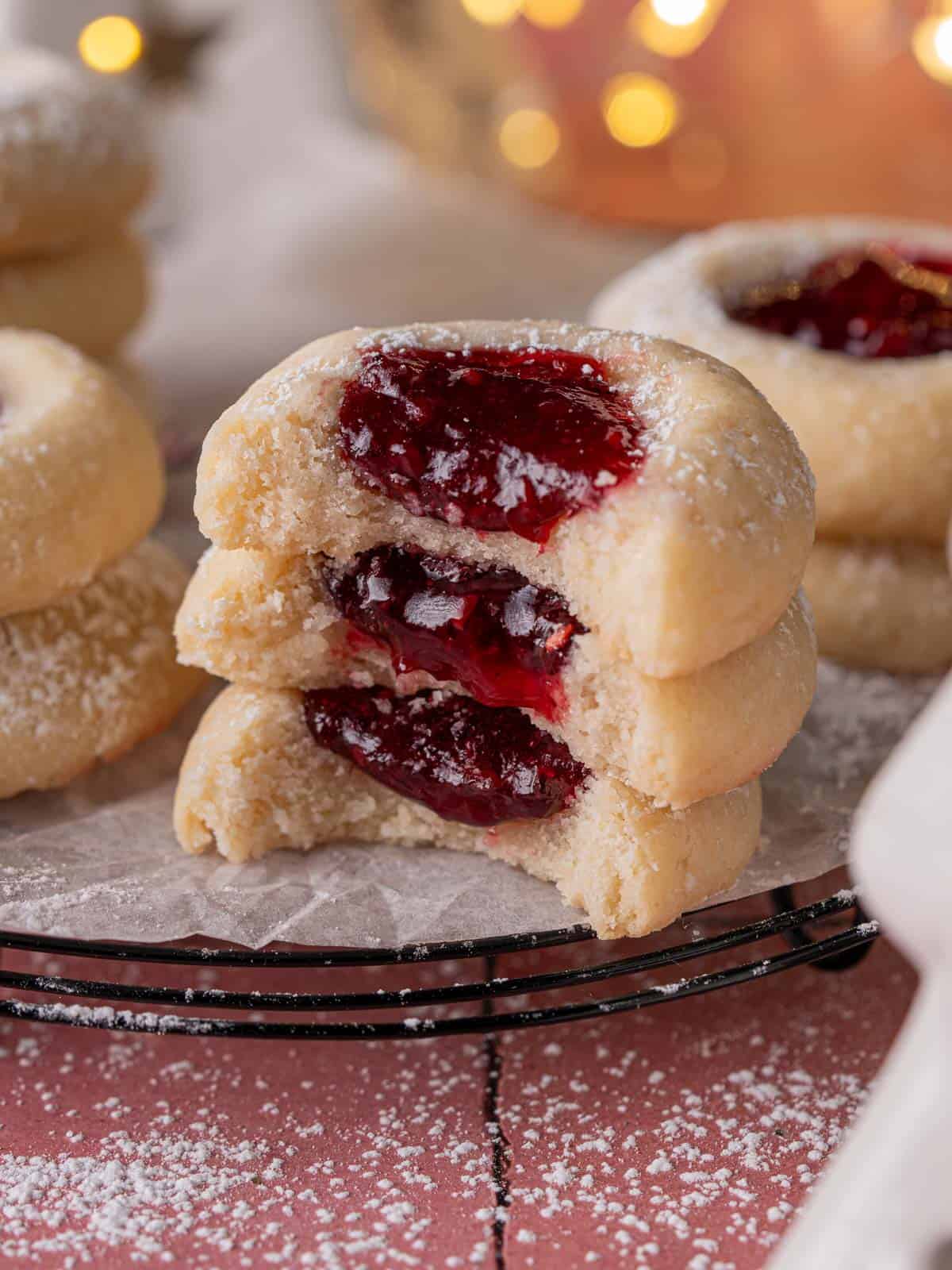 Thumbprint cookies will a bite taken out stacked on top of each other.