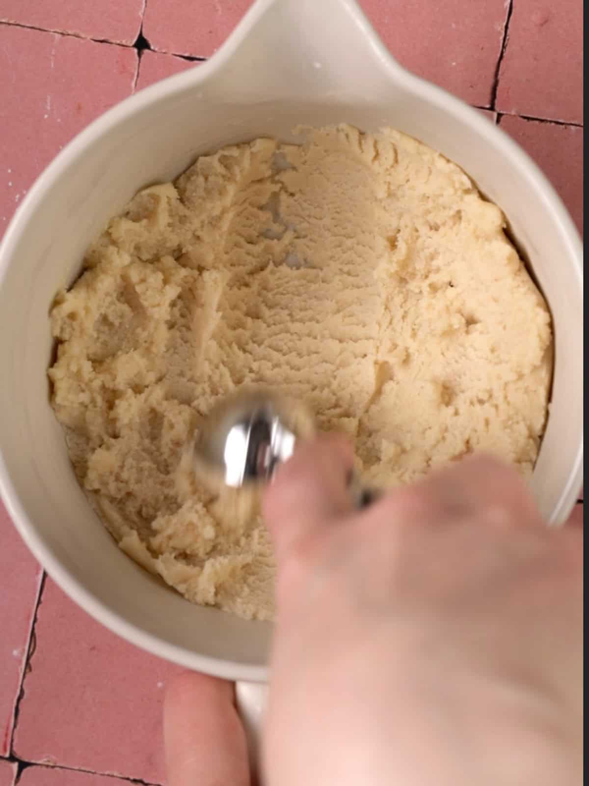 Taking a scoop out of the cookie dough before shaping into balls.