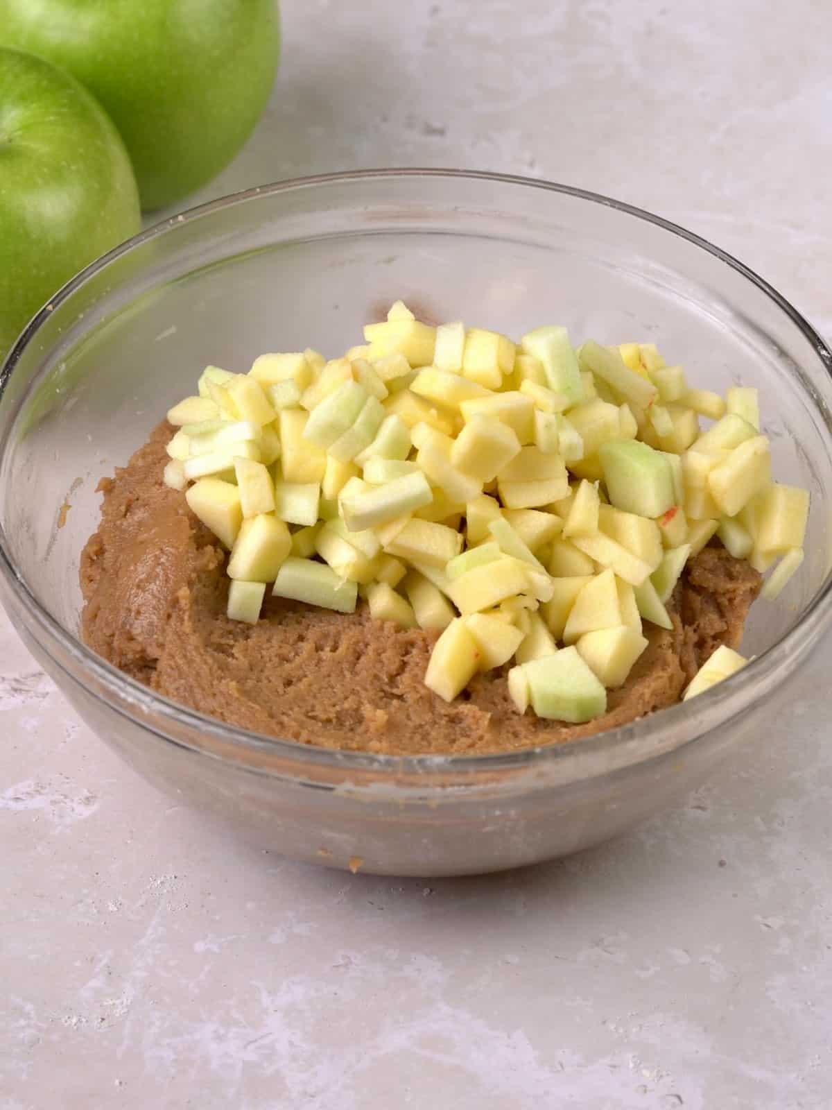 Diced apples being added to the blondie batter.