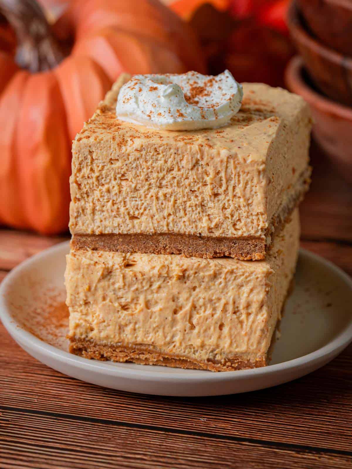 Two slices of cheesecake on top of each other with cinnamon on top.