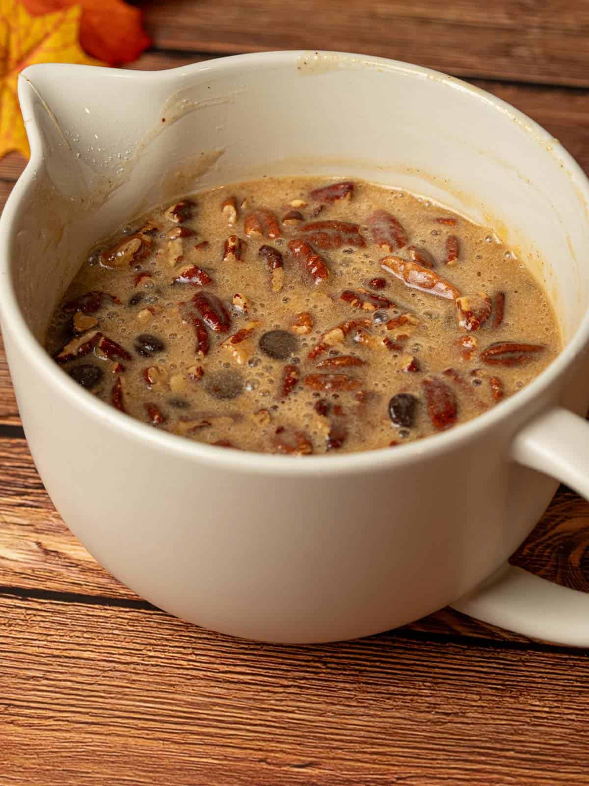Pecans and chocolate chips being added to the filling in a bowl.