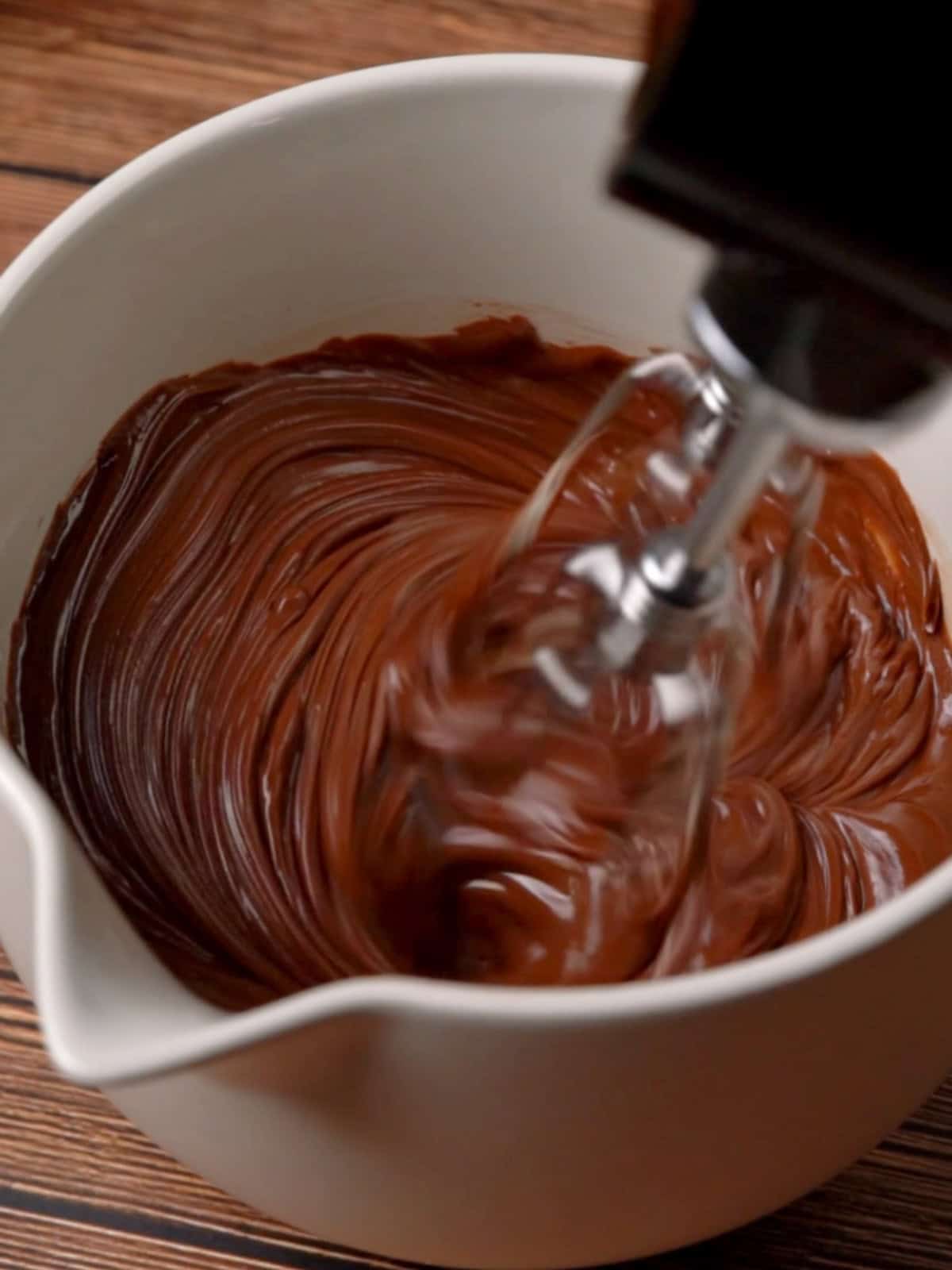 Butter, melted chocolate, and cocoa powder being mixed together.