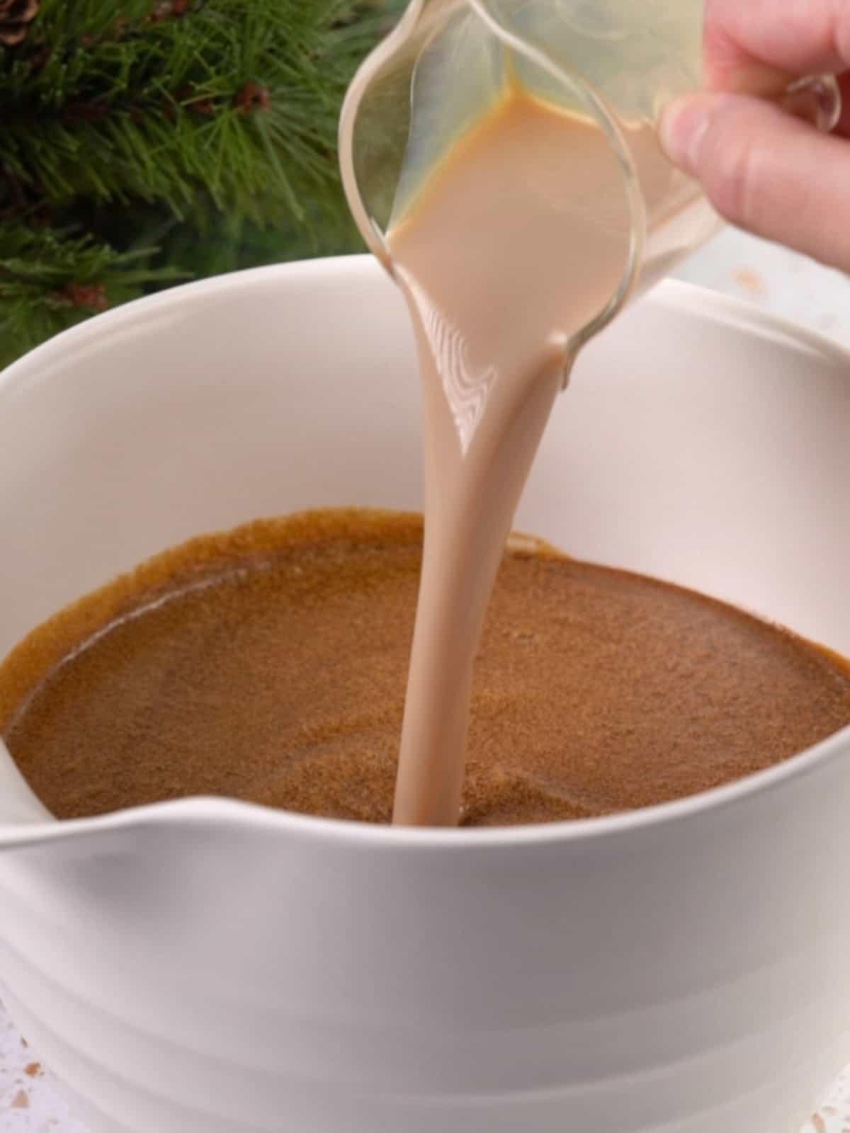 Adding liquid ingredients to the mixing bowl on the counter.