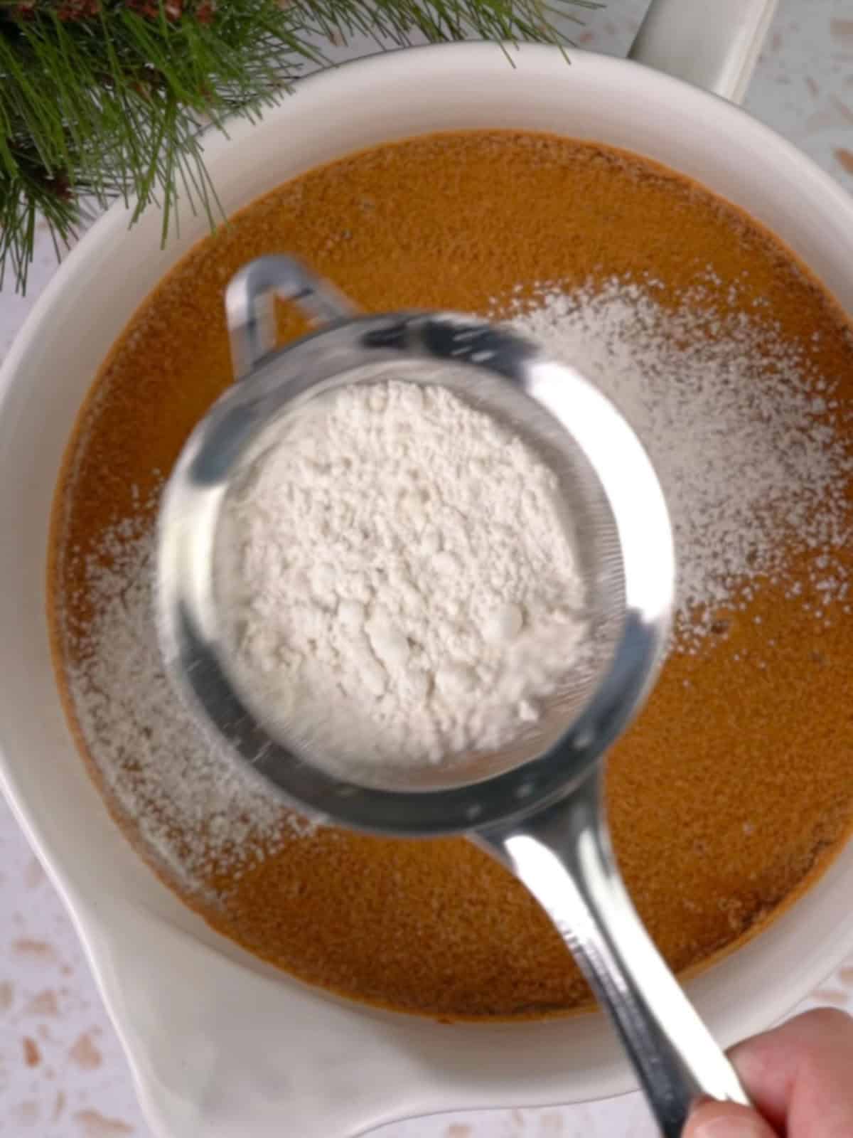 Sifting the dry ingredients into the wet ingredients.