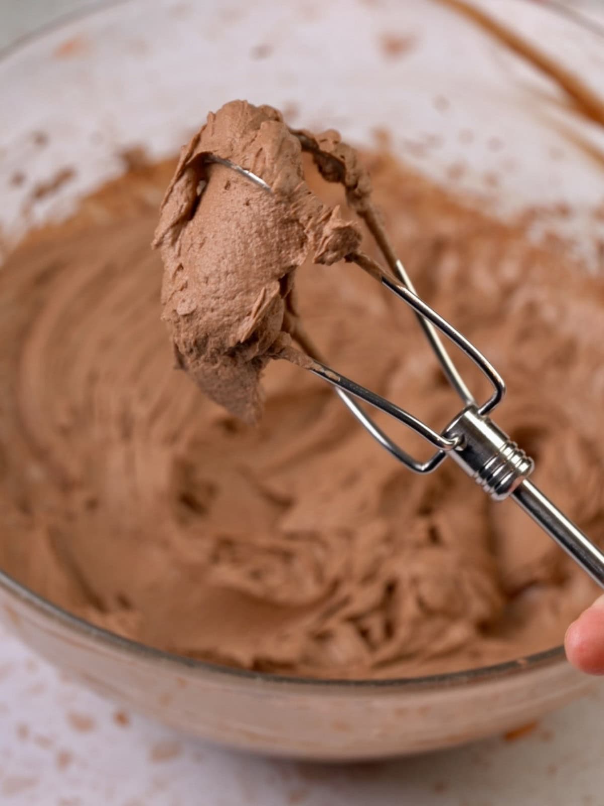 Showing the whipped chocolate ganache on a beater.