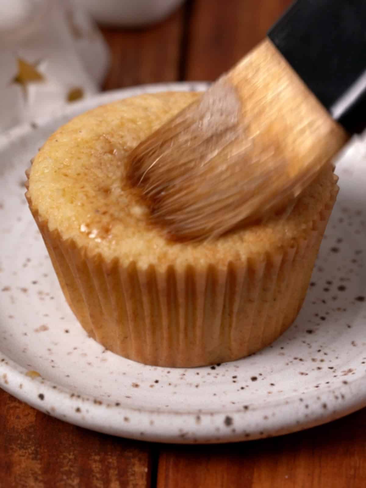 Espresso coffee liqueur mixture being brushed on top of the cupcakes.
