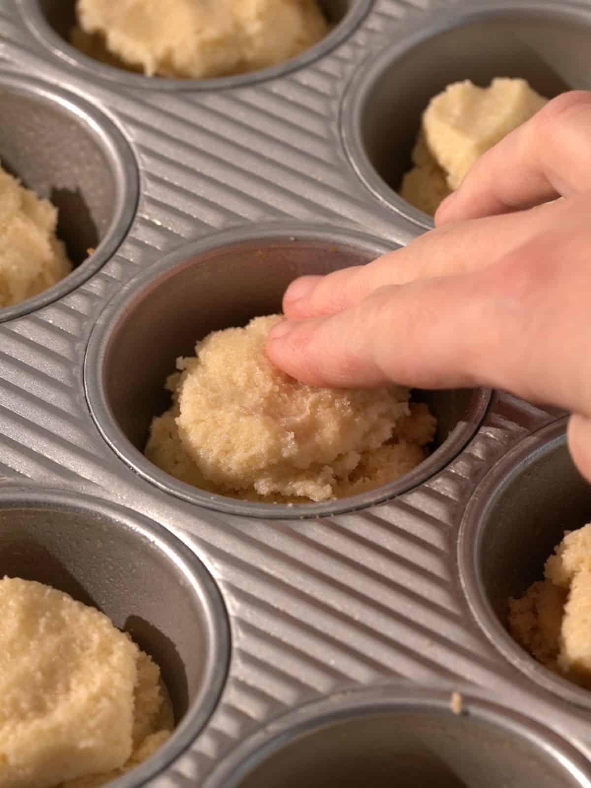 Almond frangipane filling being put on top of the cookie dough for the inside of the cookies.