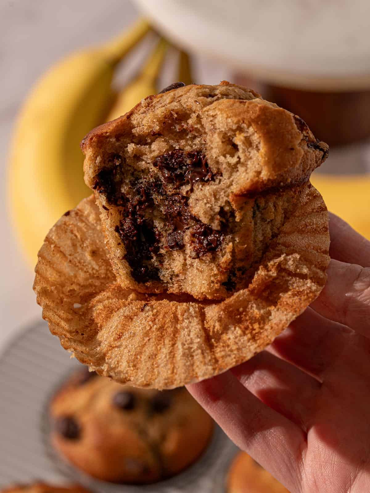 A banana chocolate chip muffin with a bite taken out.