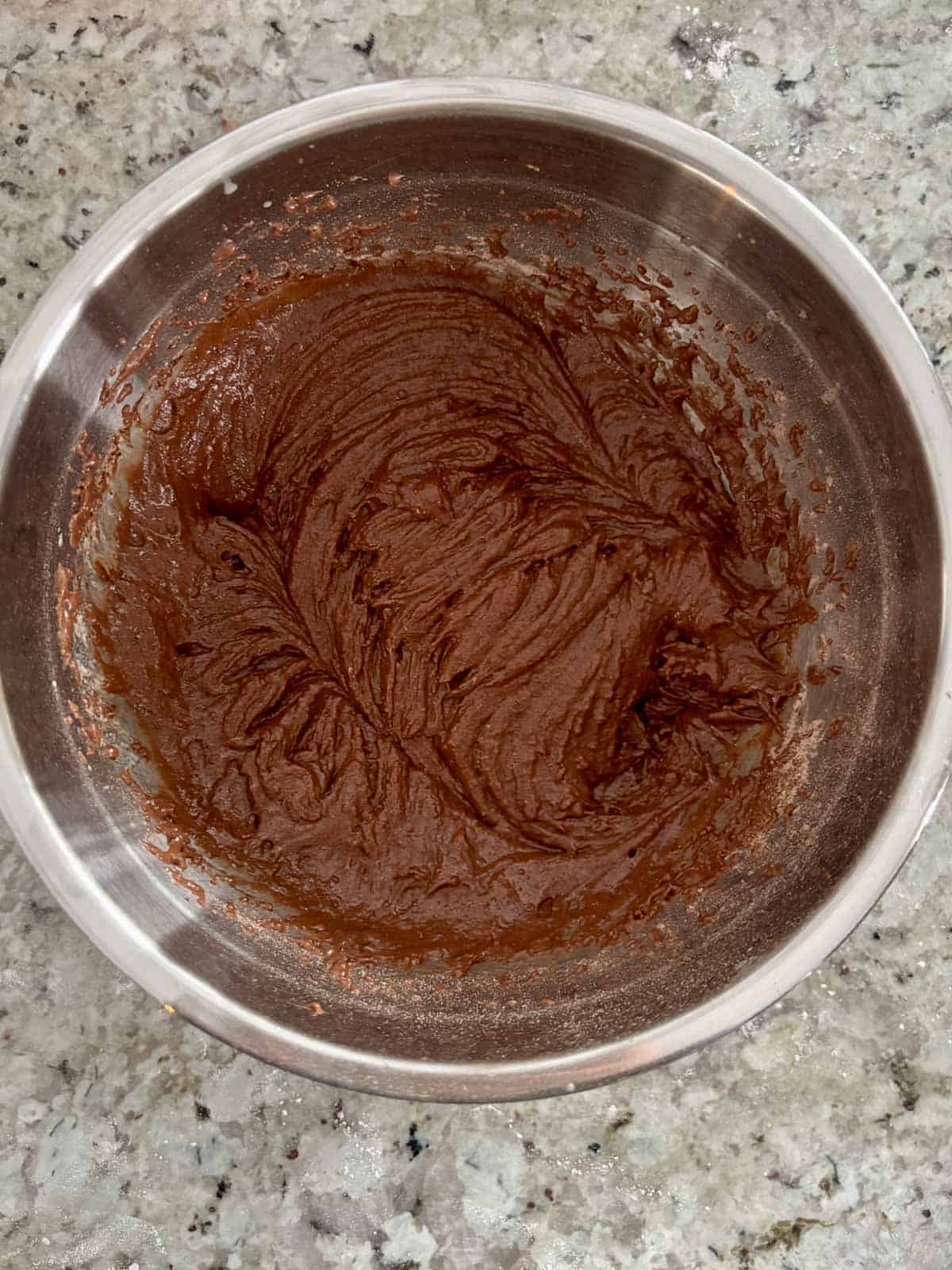 The wet ingredients being added to the dry ingredients in a bowl.