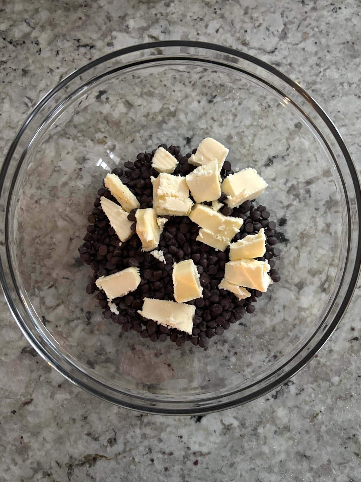 Butter and chocolate in a glass bowl on the counter.