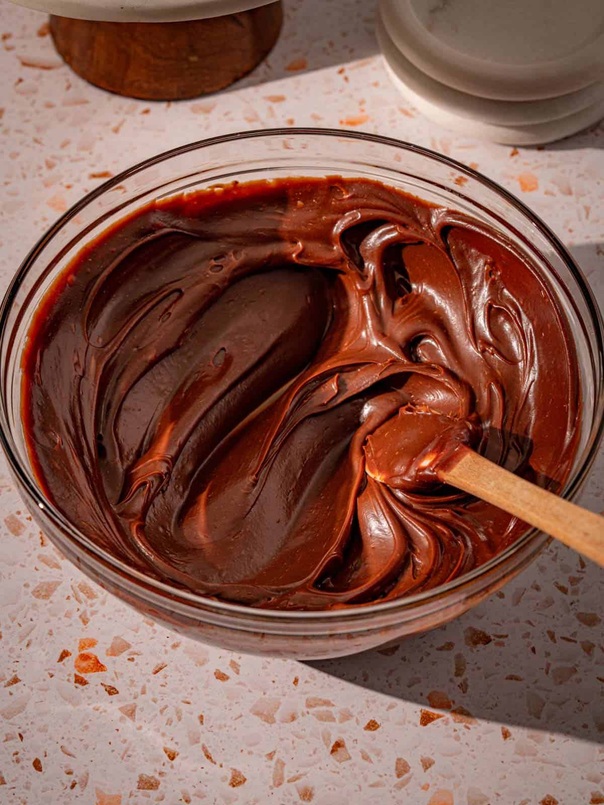 Chocolate fudge frosting in a bowl on the counter.