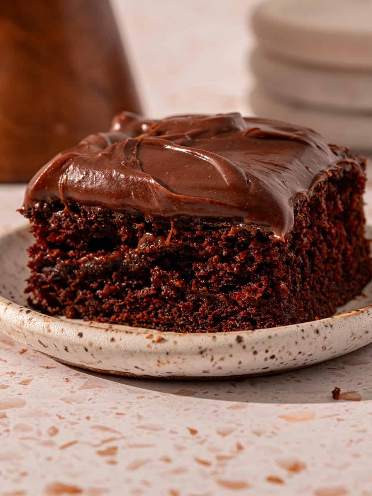 A slice of the espresso chocolate cake on a plate with fudge frosting.