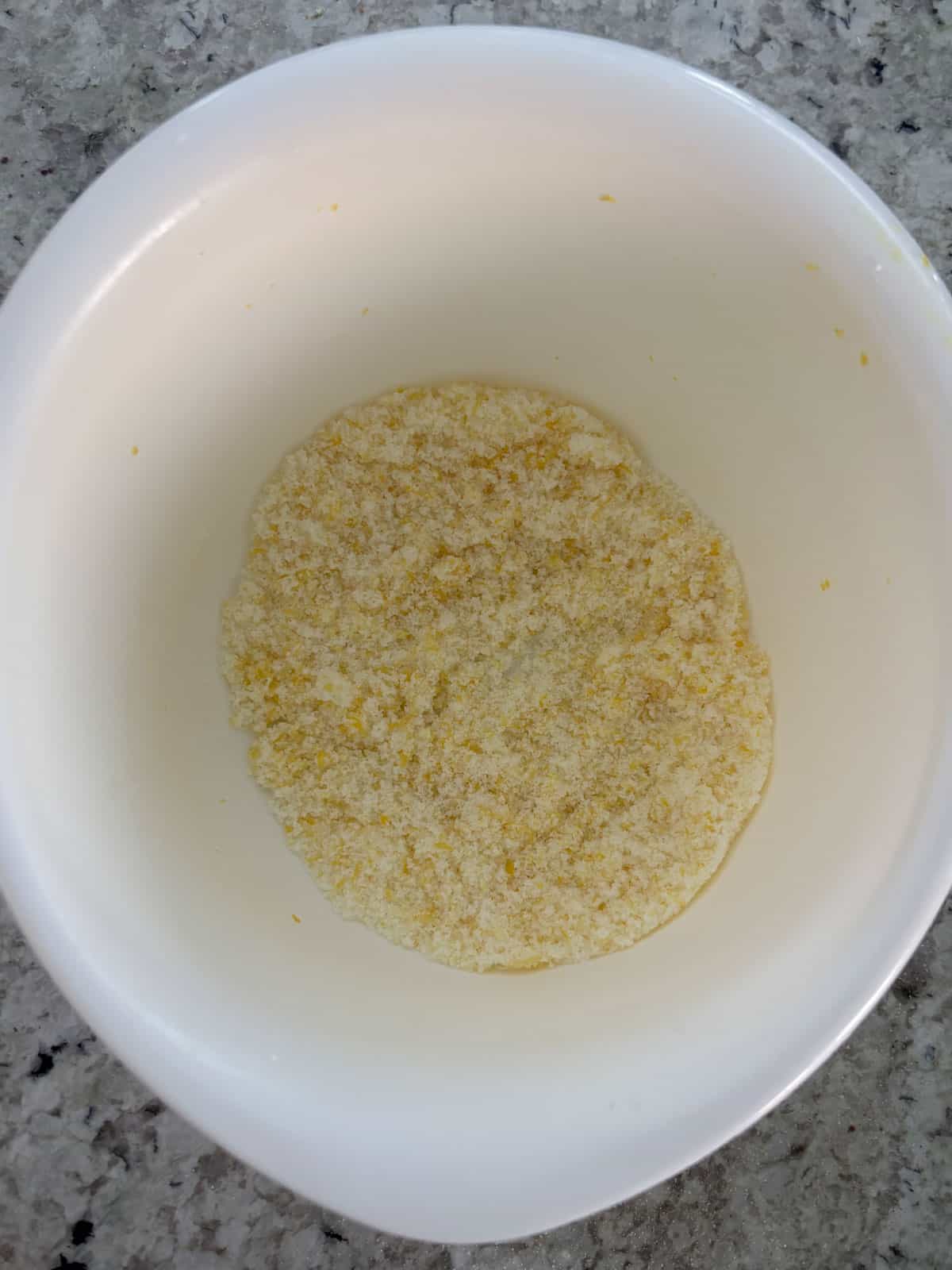 Lemon zest and granulated sugar in a bowl mixed together.