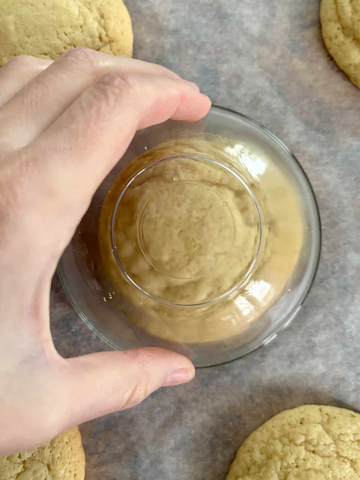 Scooting the baked cookies on a cookie sheet to make them round.