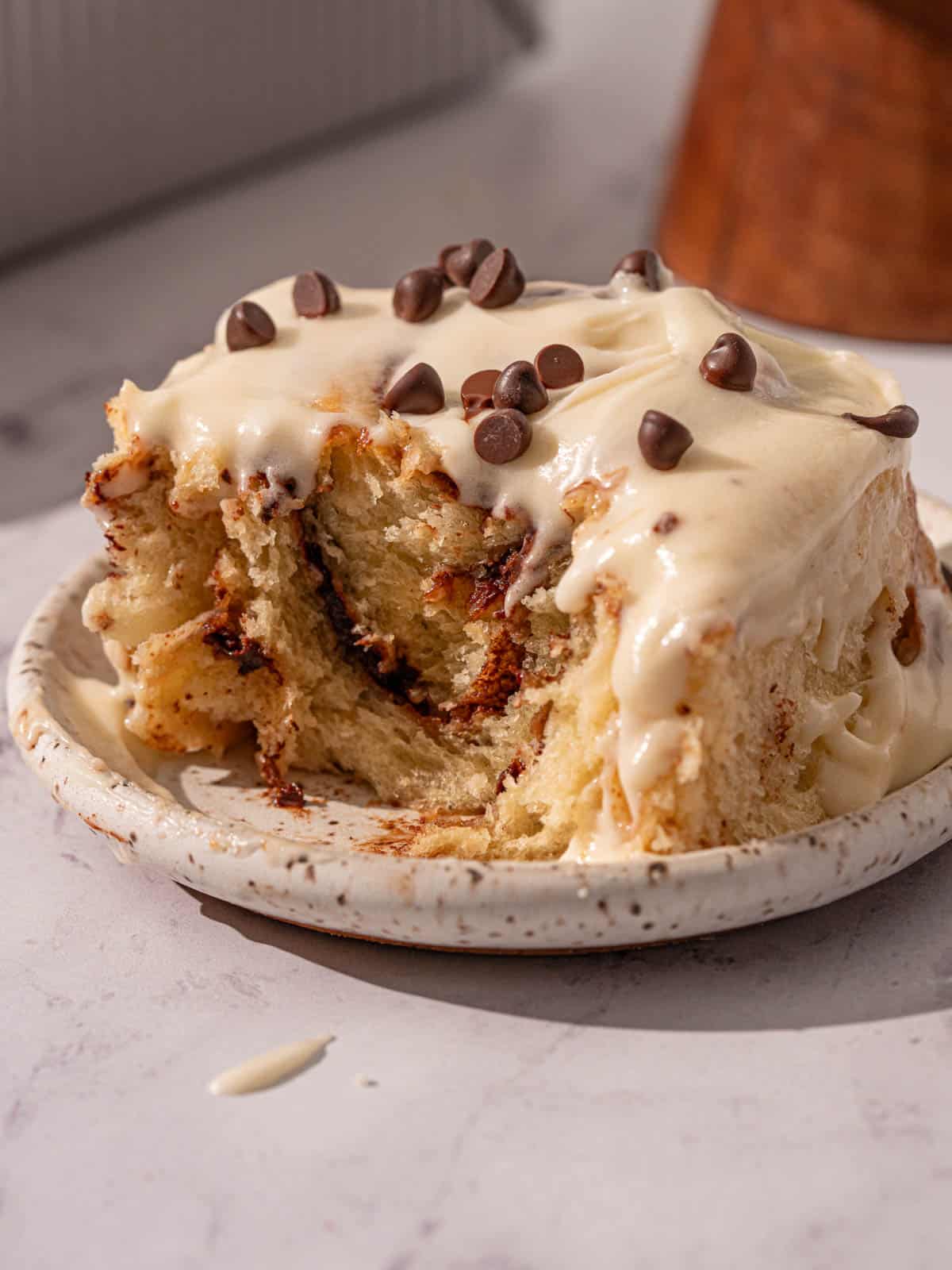 Showing the texture of the roll with cream cheese icing on top.
