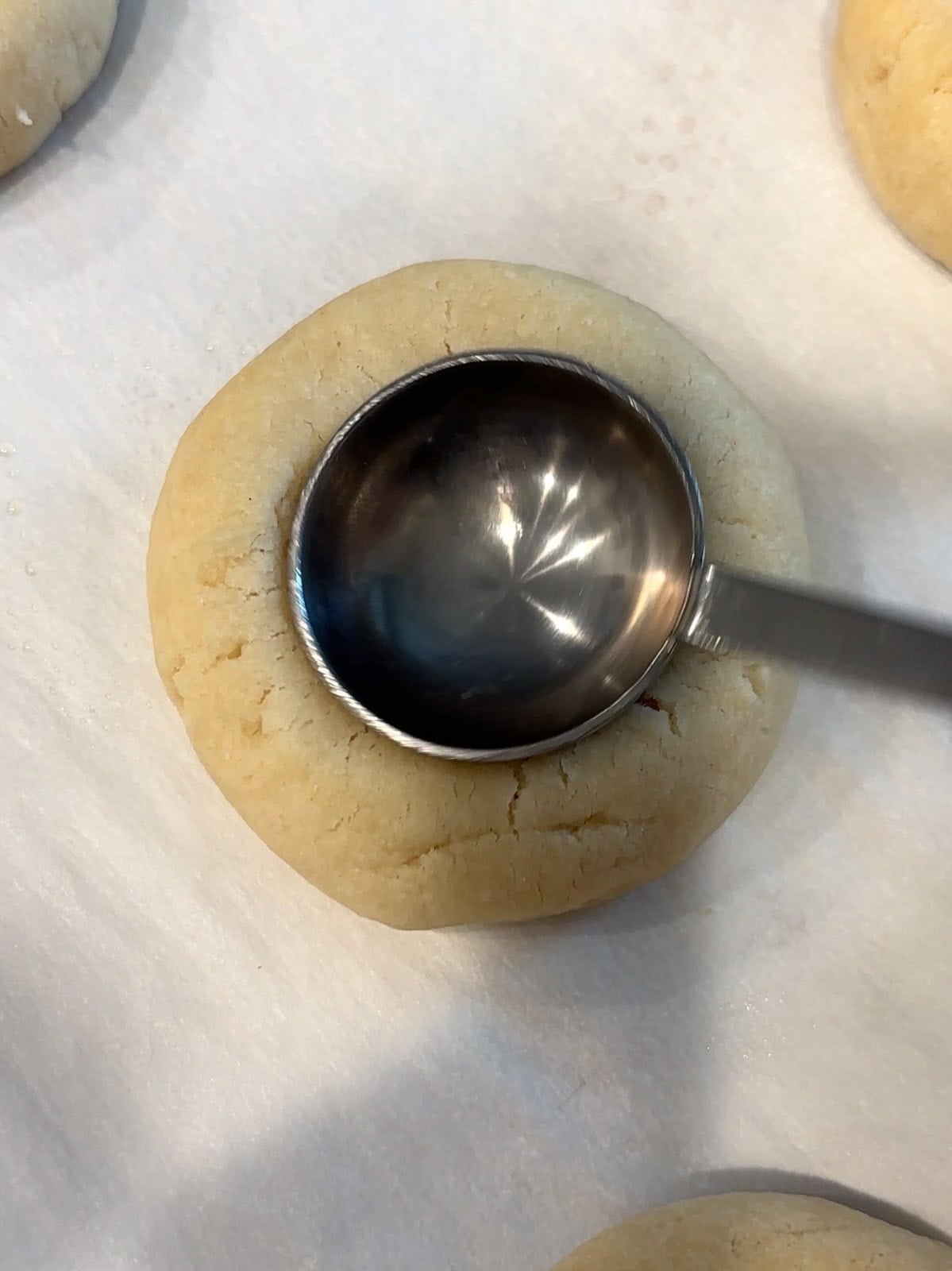 Making an indent into a warm shortbread cookie for the lemon curd.