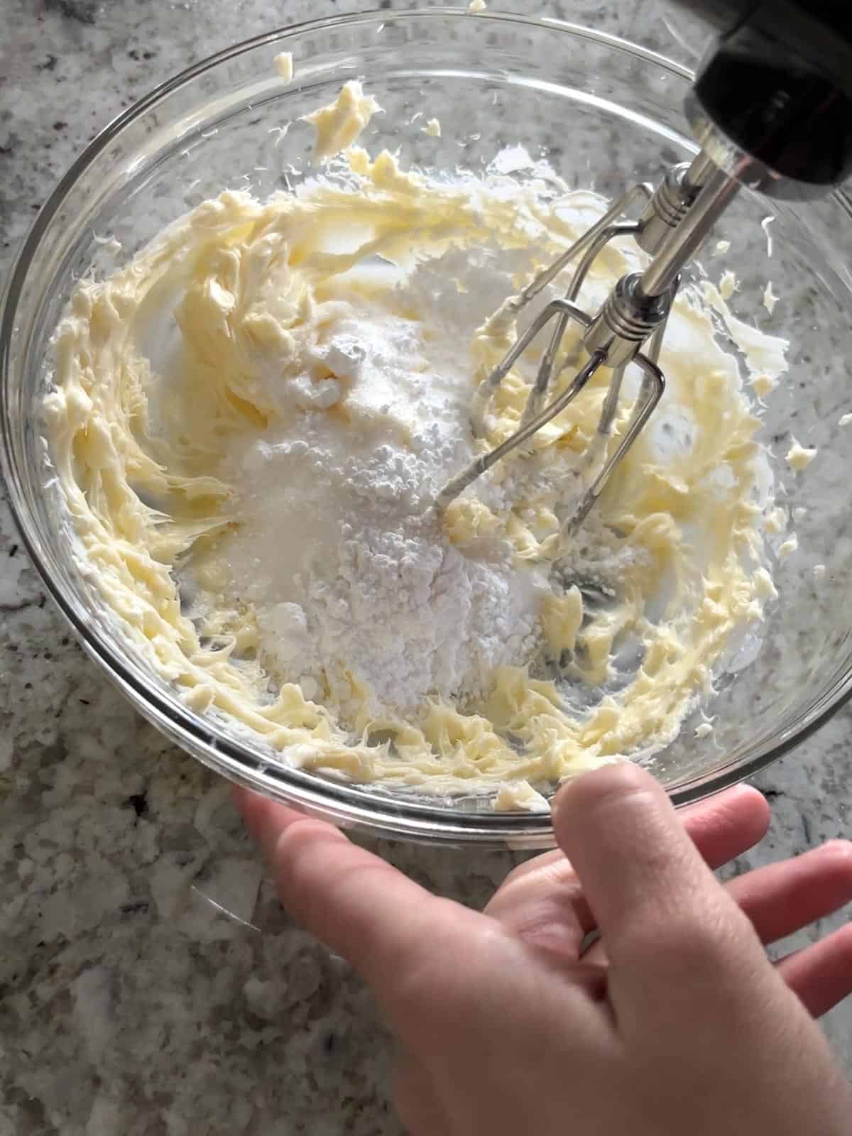 Creaming together the butter and sugars in a bowl.